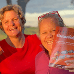 Picture of Carla Rogers and Aunty Munya Andrews holding up a copy of their book, 'Practical Reconciliation'