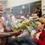 Uncle Max waving smoke onto Carla Rogers in a smoking ceremony