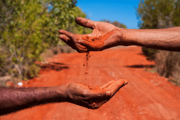 Showing Aboriginal hands holding red earth