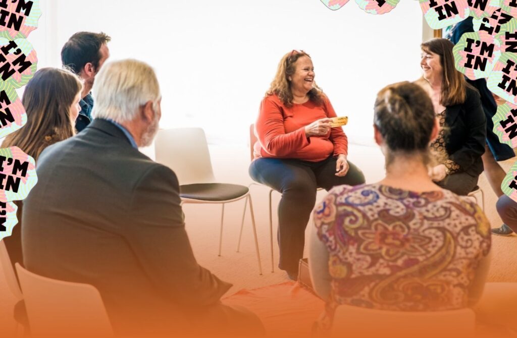 A diverse group of colleagues sitting together engaged in a respectful and open conversation about workplace allyship.
