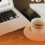A cup of tea next to hands writing a Reconciliation Action Plan, symbolising the shift from a morning tea to practical action during National Reconciliation Week.